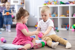share Little toddlers boy and a girl play together in nursery room. Preschool children in day care centre